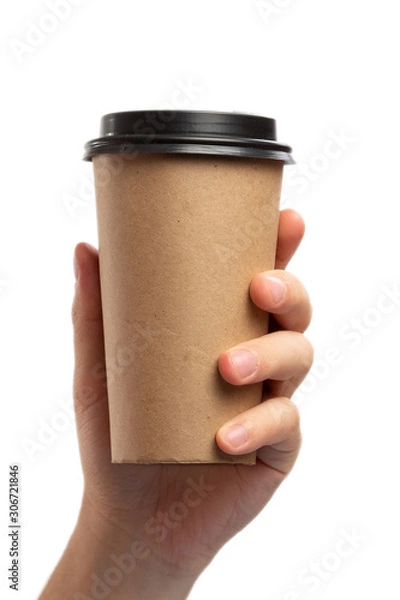 Fototapeta Breakfast and coffee theme: man's hand holding empty paper coffee cup with a brown plastic cap isolated on a white background in the studio, advertising coffee
