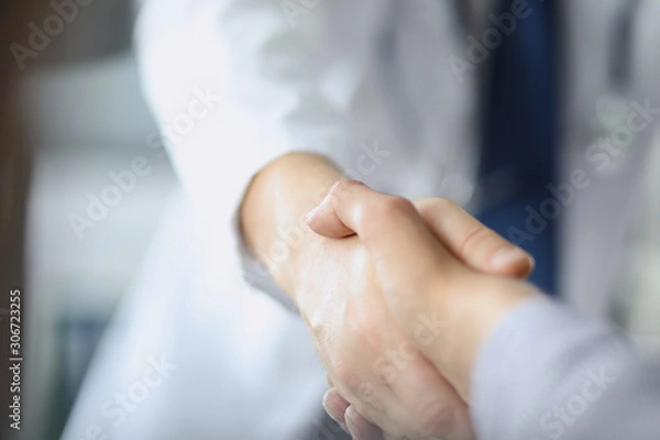 Fototapeta Closeup image of healthcare professional or doctor or dentist shaking hands with patient.