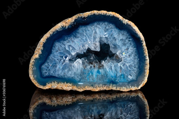 Fototapeta Geode with crystals of blue color. Quartz geode with transparent crystals on a black mirror background..