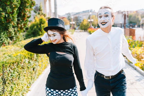 Fototapeta A couple of merry mimes. He hurries on a date.