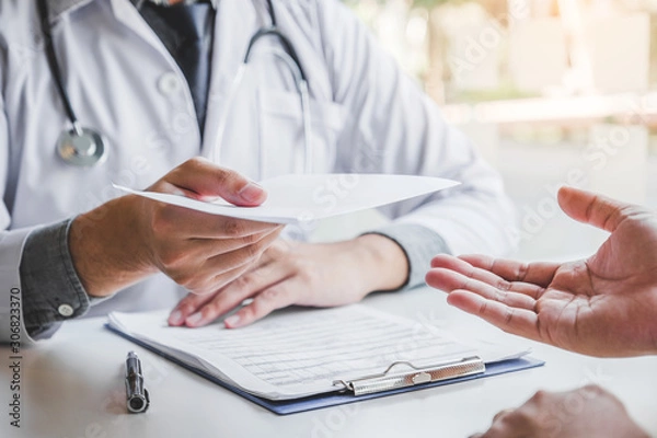 Obraz Lekarz lub lekarz piszący diagnozę i wystawiający receptę pacjentowi płci męskiej