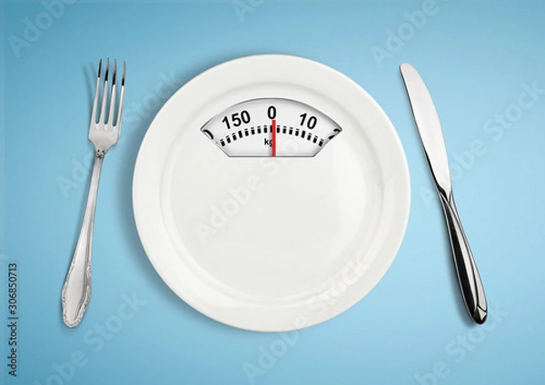 Fototapeta Diet and weight loss concept. Plate with scale weighing-machine