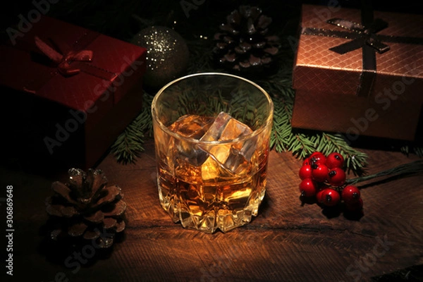 Obraz Glass with cognac or whiskey, Christmas balls and candles. New Year's tree, balls and glass with alcohol. Happy holidays decoration.