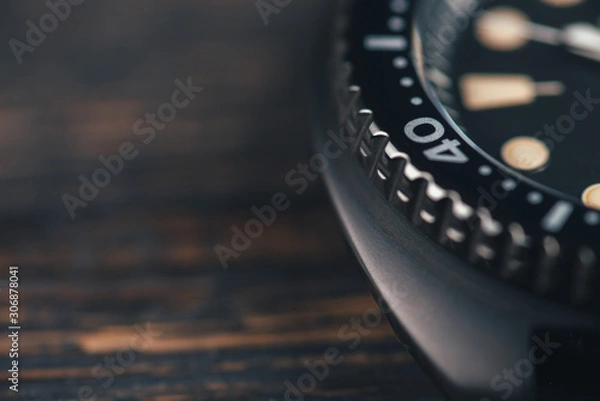 Fototapeta Close up of black diver watch dial. Rustic wooden background. Bezel with marks. Copy space. Top view. Commercial concept.
