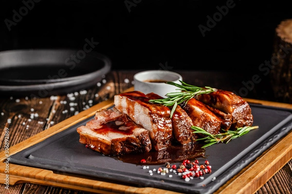 Obraz American food concept. Grilled pork ribs with grilled sauce, with smoke, spices and rosemary. Background image. copy space