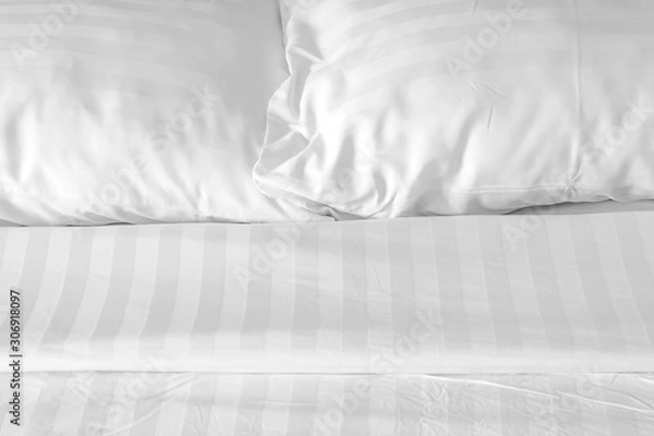 Fototapeta white pillow with messy messy blanket on bed in bedroom Close up of bedding sheets with copy space.