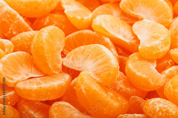 Fototapeta Lots of slices of juicy tangerines as background texture.