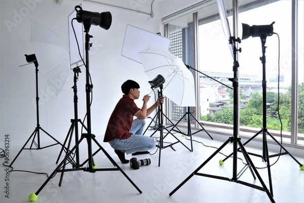 Fototapeta Photographer working with equipment lighting system camera portrait professional studio set up position