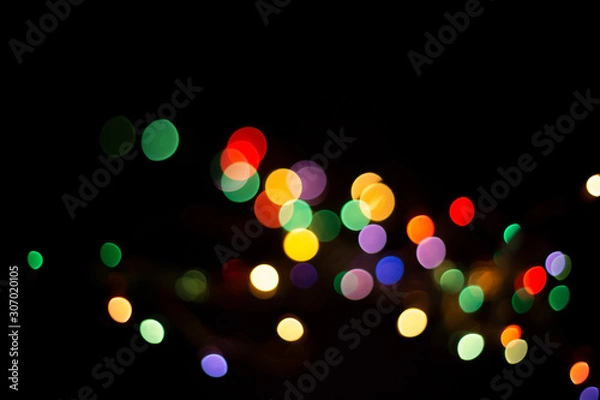 Fototapeta blur light bokeh color red green yellow on background black.