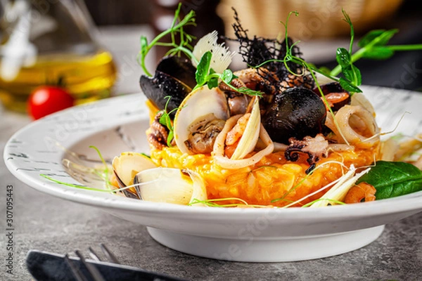 Obraz Italian food concept. Risotto with seafood, mussels, octopuses, squid. Serving dishes in a white plate. Modern serving in a restaurant. Background image. Copy space.