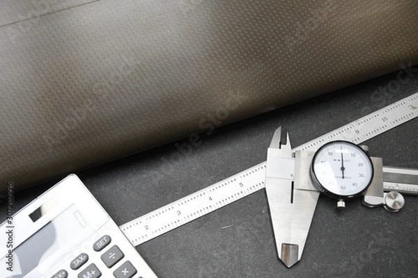 Fototapeta Calculator calipers and ruler used in quality assuarnce operations at business that need strict measurments