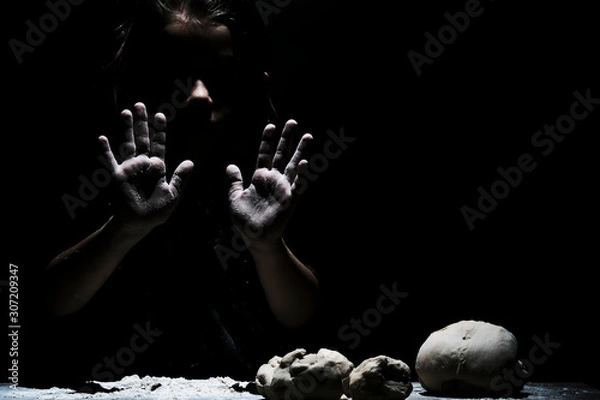 Fototapeta Little cute girl chef cooking with white flour on black background