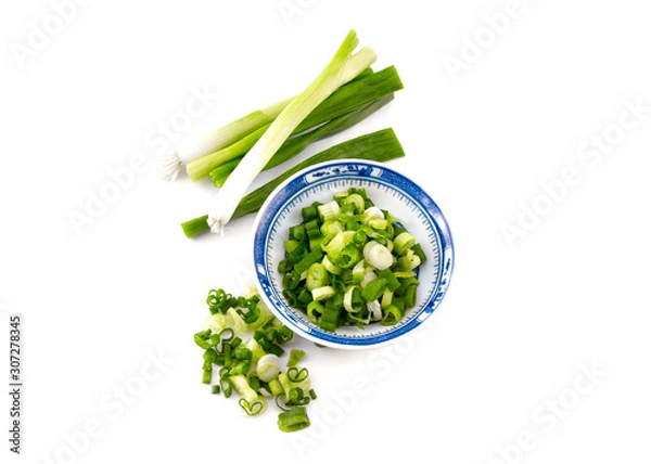 Obraz chopped spring onion, scallions, in a blue dish on white background