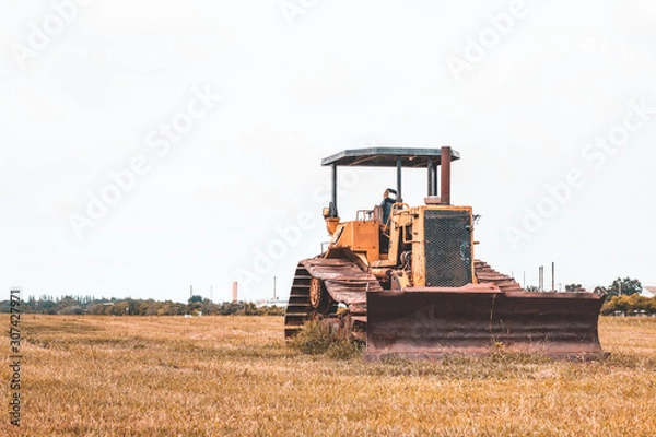 Fototapeta Old rusty tractor in field