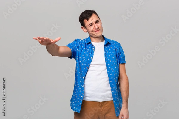 Fototapeta Man in uncertain if he likes or dislikes the object.