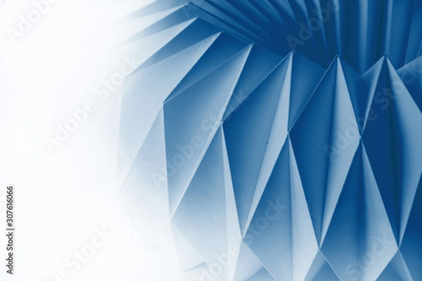 Fototapeta Macro image of white paper folded in geometric shapes, three-dimensional effect, abstract background. Out of focus.