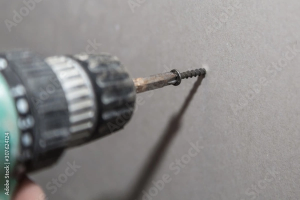 Obraz Working with an electric screwdriver.  Screw gun.