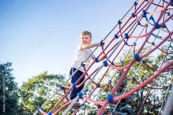 Obraz Cute kid climbing on playground in park