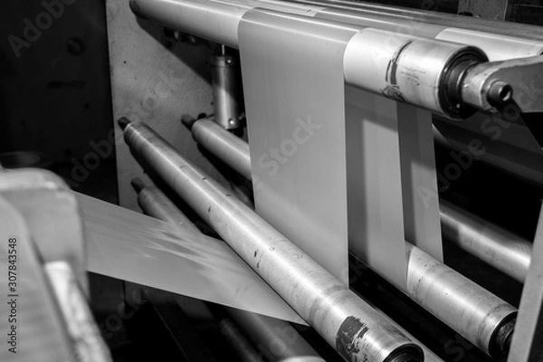 Obraz Black & White imagery of spool of plastic packaging sheet heavy duty for industrial use outdoors. wrapped around a metal pole ready to feed into a machine for cutting into shape or printing logos.