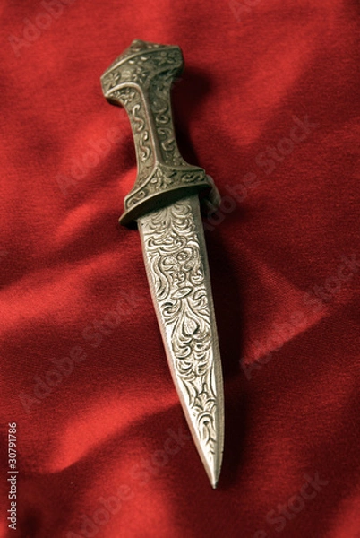 Obraz Antique dagger on red stain background