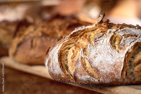 Fototapeta Chleb na zakwasie z chrupiącą skórką na drewnianej półce. Wyroby piekarnicze