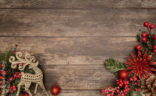 Fototapeta Christmas fir tree with poinsettie reindeer and ornaments on wooden background