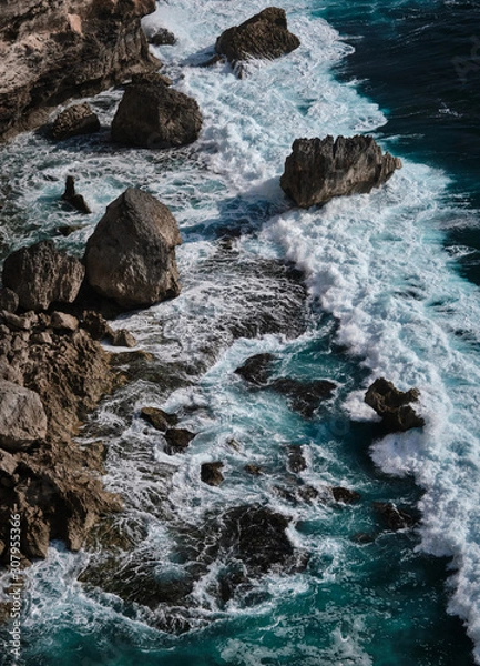 Fototapeta Aerial view to ocean waves with rocks. Blue water background. Bali, Indonesia.