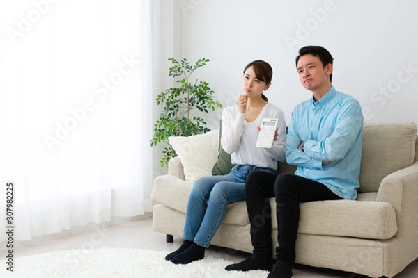 Fototapeta 電卓を持って家計を相談する夫婦