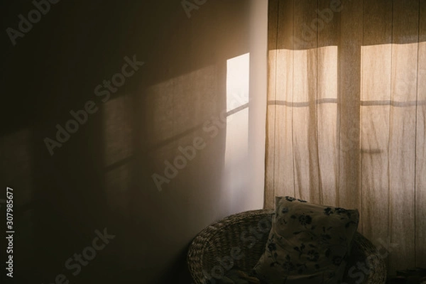 Fototapeta cozy window with curtains in the room. Shadow and sunlight on the wall. Pillow in wicker chair