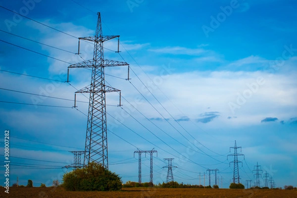 Fototapeta Group silhouette of transmission towers (power tower, electricity pylon, steel lattice tower) at twilight in US. Texture high voltage pillar, overhead power line, industrial background. Copy space