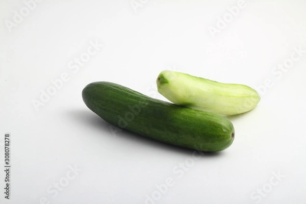 Fototapeta whole peeled and unpeeled fresh cucumber on white background