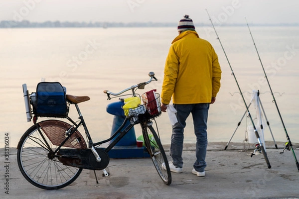 Fototapeta A fisherman waits for the fish to take the bait. Port of Rimini