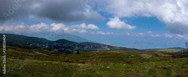 Fototapeta Panorama view of colorful mountains, meadow, and valley with clouds in the background.Ski resort. Early morning, Sharr Mountains, Popova Shapka, North Macedonia.