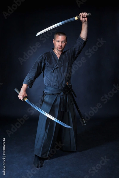 Fototapeta Man in a kimono holding two Samurai swords