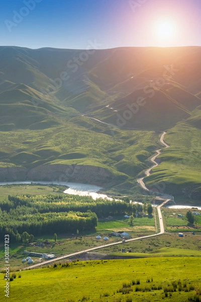 Obraz Alpine meadow with winding road in mountain ranges