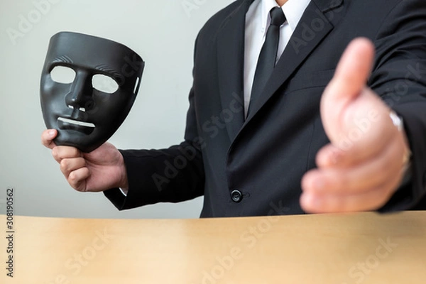Fototapeta A business man with a black mask covering the insincerity of doing business together.Corruption concept.