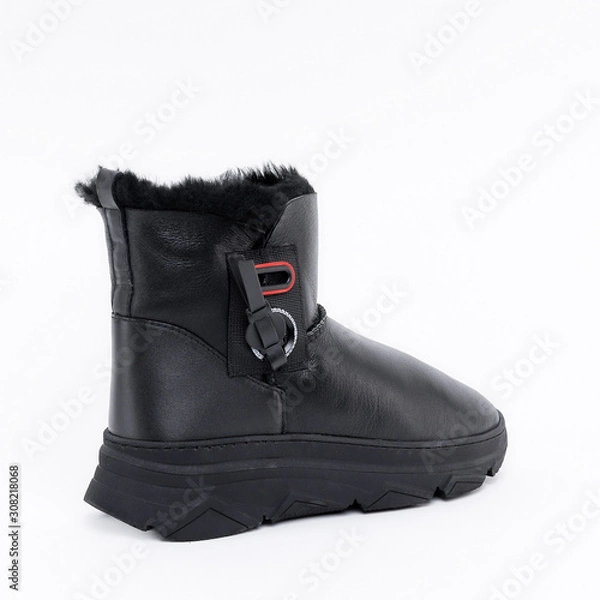 Fototapeta Beautiful black stylish winter soft female ankle boots with warm fur inside. On white background. See other angles of this boot and other models in my profile