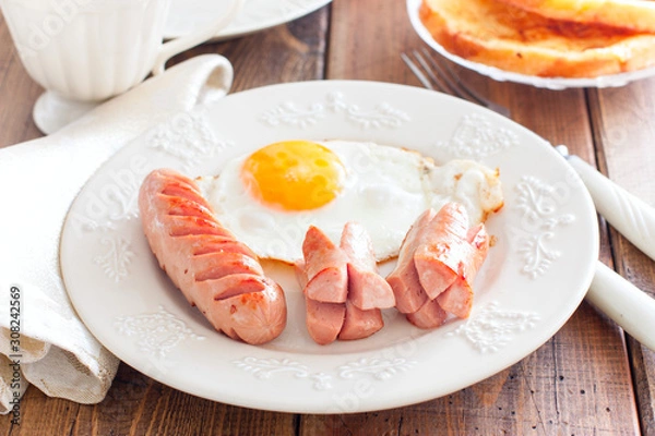 Fototapeta Fried sausages with fried eggs, selective focus