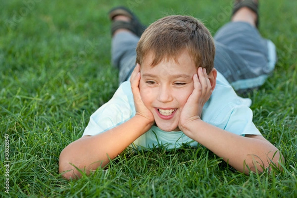 Obraz Cheerful boy lying on the lawn