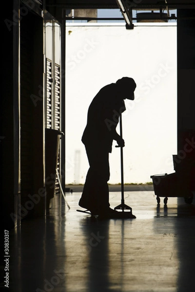 Obraz Silhouette of man moping floor