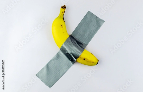 Obraz Banana duct taped to the white wall. Conceptual photo.