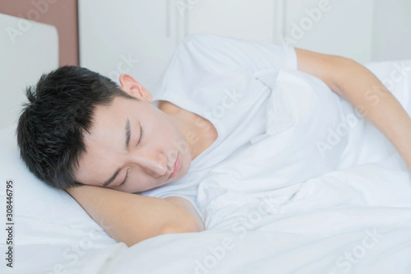 Obraz side view of bearded man sleeping on bed, lying on side