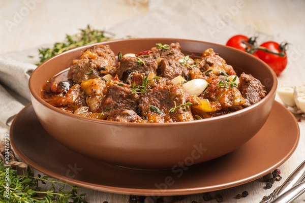 Fototapeta Braised meat with vegetables in a thick sauce.