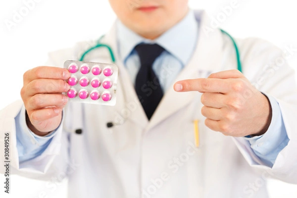 Fototapeta Medical doctor pointing finger on pack of pills. Close-up.