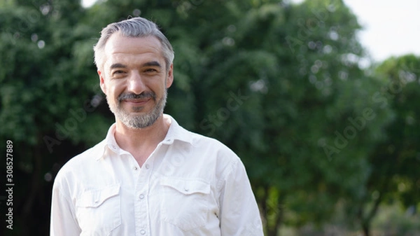 Fototapeta Portrait of middle aged man in the park and smiling. 