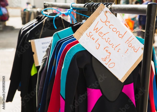 Obraz Second hand wetsuits starting from only £10 pounds on sale rack preowned so surfers swimmers bodyboards can all go into the cold sea and stay warm. Great for doing waterspouts in England