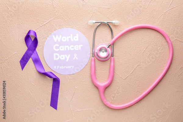 Fototapeta Paper with text WORLD CANCER DAY, stethoscope and purple ribbon on color background