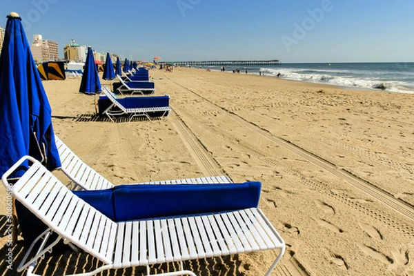 Obraz Lounge chairs and umbrellas awaiting seaside visitors at Virginia Beach, Virginia