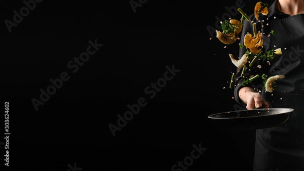Fototapeta Owoce morza, smażenie krewetek z warzywami, szef kuchni na czarnym tle. Baner reklamowy do sprzedaży owoców morza, na czarnym tle do projektowania