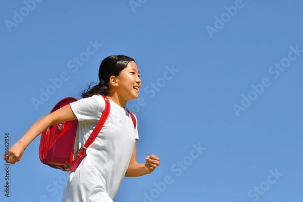 Fototapeta 青空で走る小学生の女の子（ランドセル）